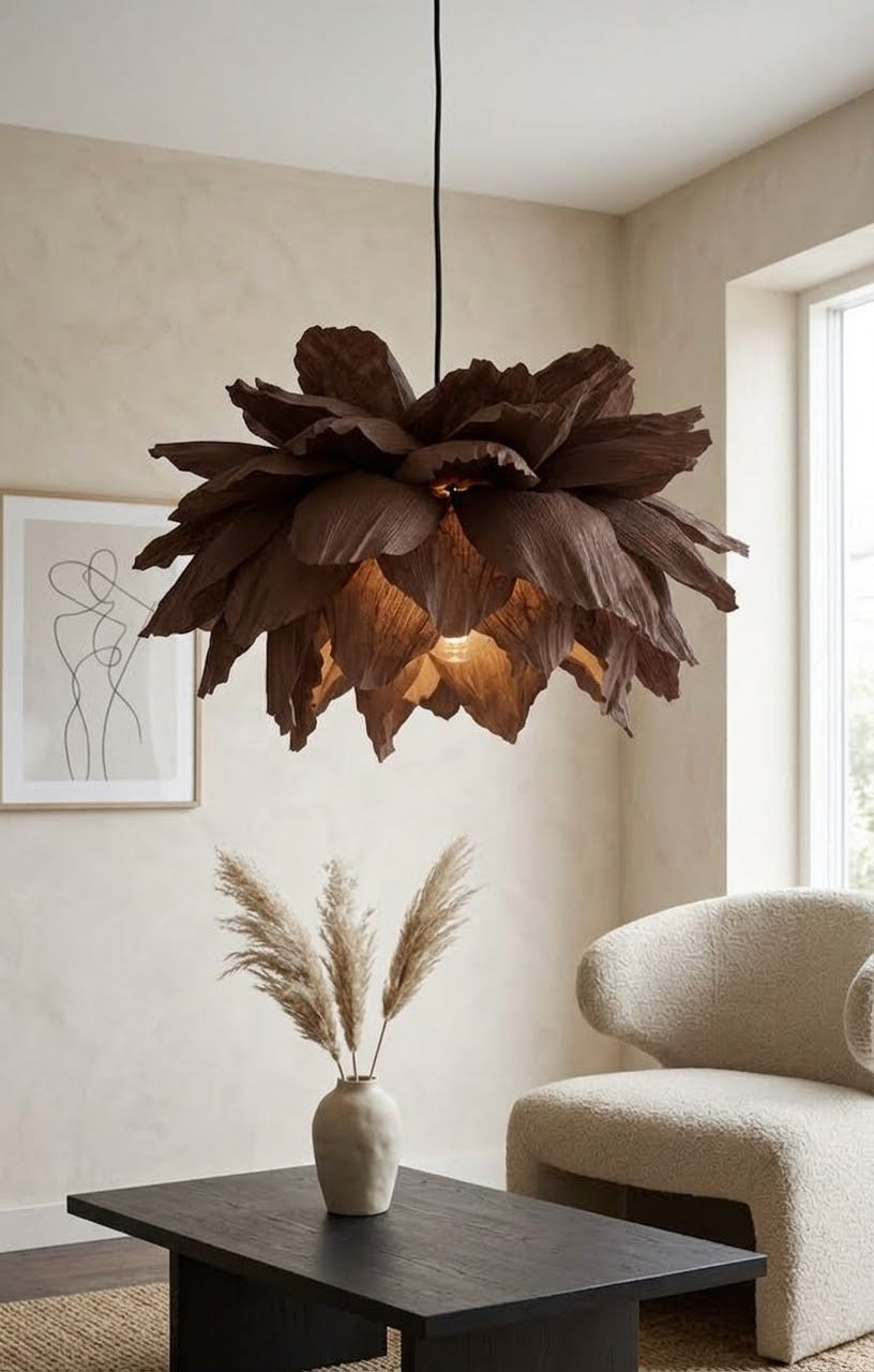 Mørkebrun taklampe i kreppapir, tent, over sofabord og lys sofa